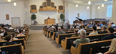 Attendees in the pews of Free Reformed Church during a session