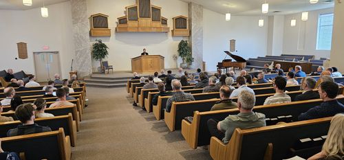 Attendees seated in the pews of the host church sanctuary during a conference session